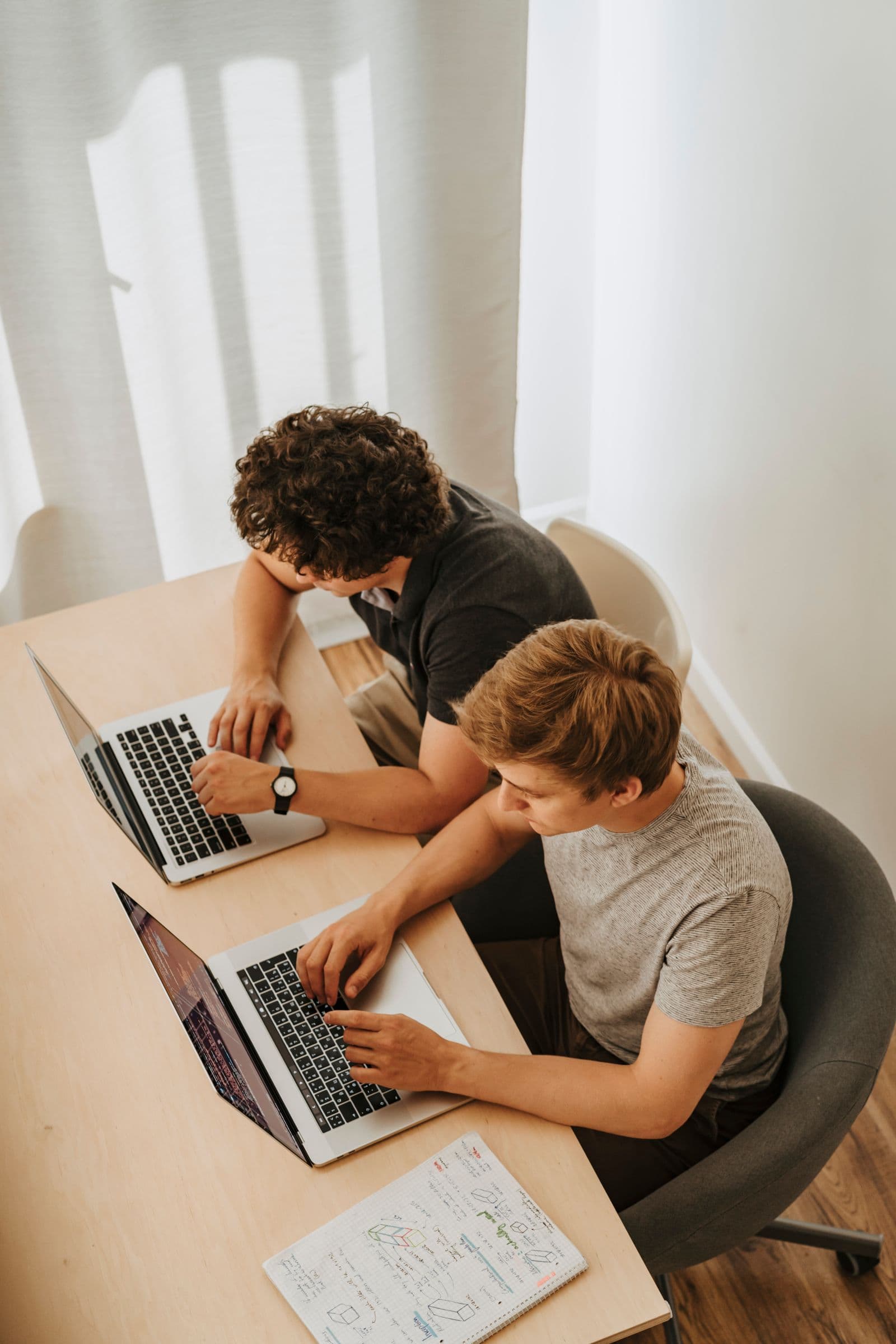Two people working on laptops